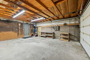 Below grade area with a garage, a heating unit, and a workshop area