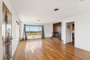 Unfurnished living room with light wood-style floors and a brick fireplace