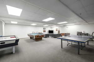 Playroom with carpet, a paneled ceiling, and pool table