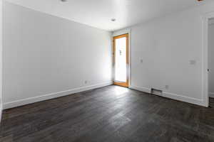 Spare room with dark wood-type flooring and a textured ceiling