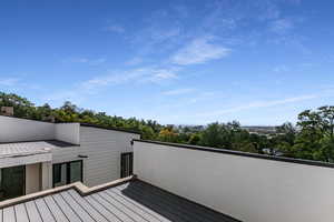 Balcony with a roof deck and view of scattered trees