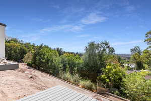 View of yard with a wooden deck and view of wooded area