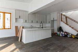 Kitchen featuring dark wood-type flooring, a kitchen island with sink, modern cabinets, light stone counters, and recessed lighting