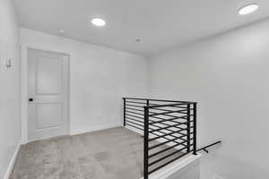 Stairs with carpet and recessed lighting