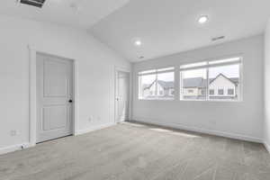Unfurnished bedroom with vaulted ceiling, light carpet, and recessed lighting