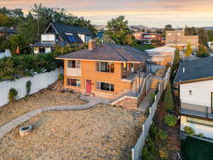 View of front of home with a fenced backyard, a residential view, a chimney, brick siding, and stairs