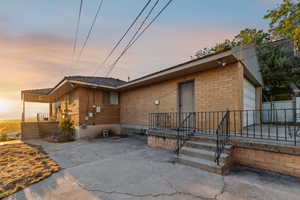 Rear view of property featuring brick siding and driveway