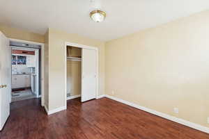 Unfurnished bedroom with dark wood finished floors and a closet