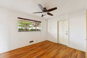 Empty room featuring light wood-style flooring and a ceiling fan