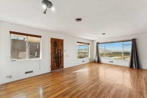 Unfurnished living room with light wood-style flooring and a mountain view