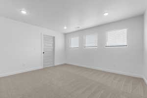 Spare room with light carpet and recessed lighting