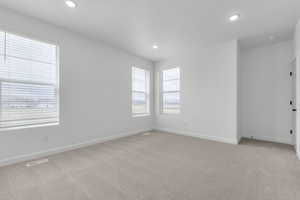 Empty room featuring light carpet and recessed lighting