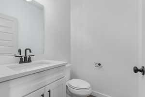 Half bathroom featuring vanity and toilet