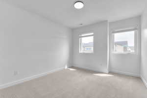 Carpeted empty room featuring baseboards