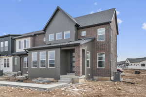 View of front of house with brick siding and roof with shingles