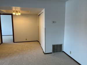 Empty room featuring light carpet and baseboards