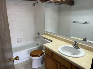 Bathroom with vanity, bathtub / shower combination, and light tile patterned floors