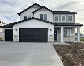 Modern inspired farmhouse featuring stone siding, a porch, concrete driveway, and roof with shingles