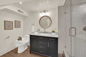 Full bath featuring a shower stall, vanity, and wood finish floors