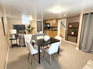 Dining area with stairway and light carpet