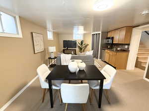 Dining space with stairs and light colored carpet