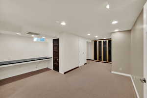 Finished basement with recessed lighting and light colored carpet