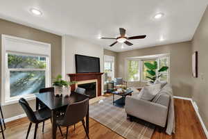 Living room with a fireplace with flush hearth, light wood-style floors, a ceiling fan, and recessed lighting