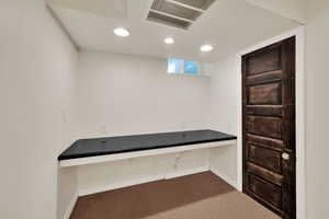 Unfurnished office with dark carpet and recessed lighting