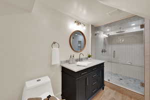 Bathroom featuring vanity, a stall shower, and light wood-style flooring