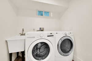 Laundry area featuring washer and clothes dryer and wood finished floors