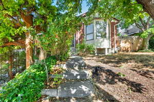 View of property hidden behind natural elements featuring brick siding