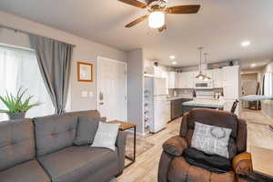 Living area with light wood finished floors, recessed lighting, and a ceiling fan