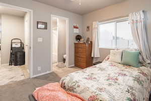 Bedroom with light carpet and connected bathroom