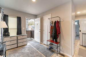 Foyer with light wood finished floors and recessed lighting