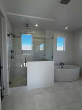 Full bathroom with a soaking tub, a stall shower with bench, and tile patterned flooring