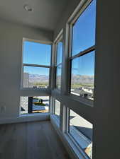 Corner windows with a mountain view and light engineered hardwood floors