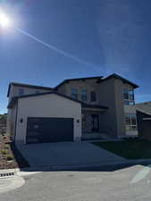 View of front of property with a garage and driveway