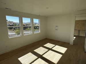 Primary bedroom with a mountain view and light engineered hardwood floors