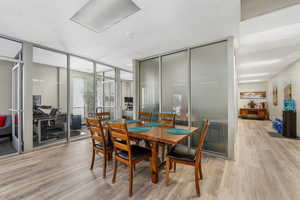 Dining room with light wood-type flooring and floor to ceiling windows