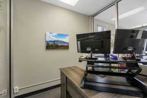 Office space with a paneled ceiling and baseboards