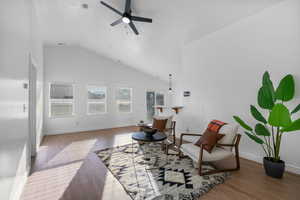 Living area with wood finished floors, high vaulted ceiling, and ceiling fan