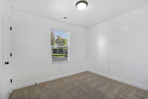 Empty room with carpet and baseboards