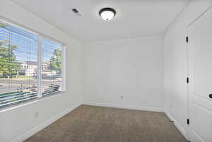 Unfurnished bedroom with carpet flooring and baseboards
