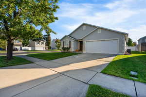 Ranch-style home with driveway, stucco siding, a residential view, and a garage