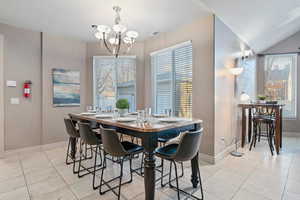 Dining area with light tile patterned floors and a chandelier