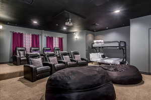 Carpeted cinema room with recessed lighting