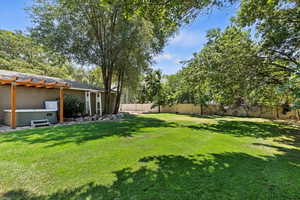 Fenced backyard featuring a hot tub