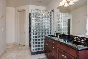 Bathroom featuring light tile patterned floors and double vanity