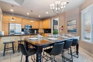 Dining space featuring light tile patterned flooring, a chandelier, and recessed lighting