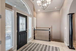Foyer featuring ornamental molding, light tile patterned floors, recessed lighting, and a chandelier